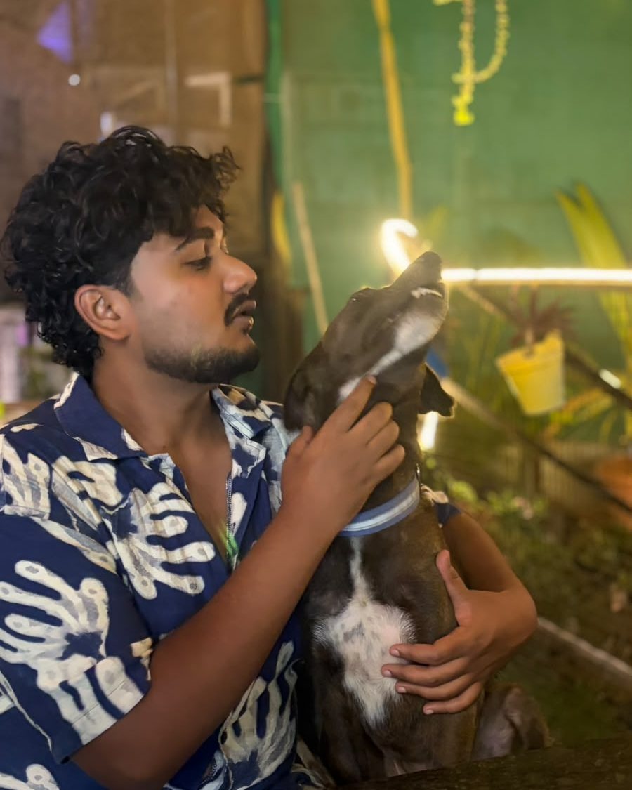 A guest cuddling a dog at the cafe in the evening