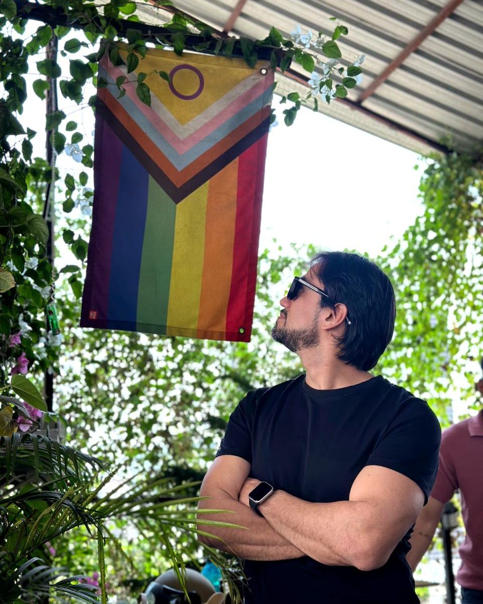 A guest looking up at the progress pride flag hanging at the cafe