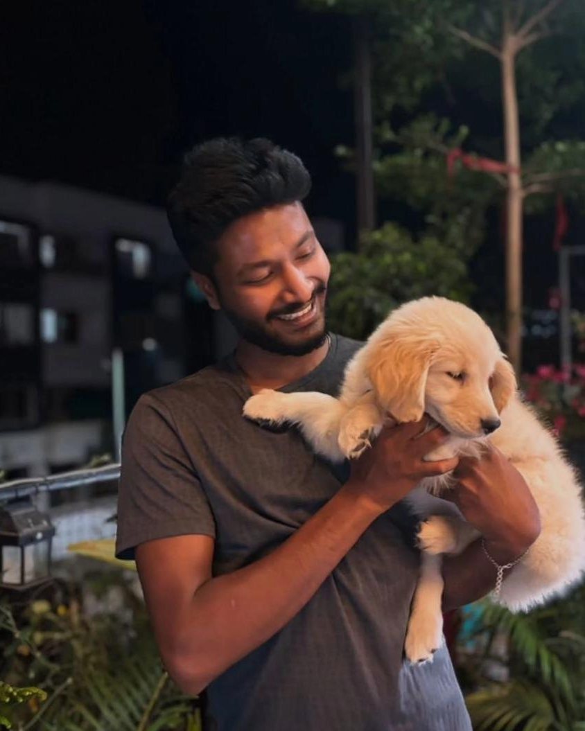A smiling guest holding a golden retriever puppy